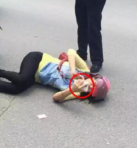 一女子躺马路边玩微信，身边还有交警“保护”？